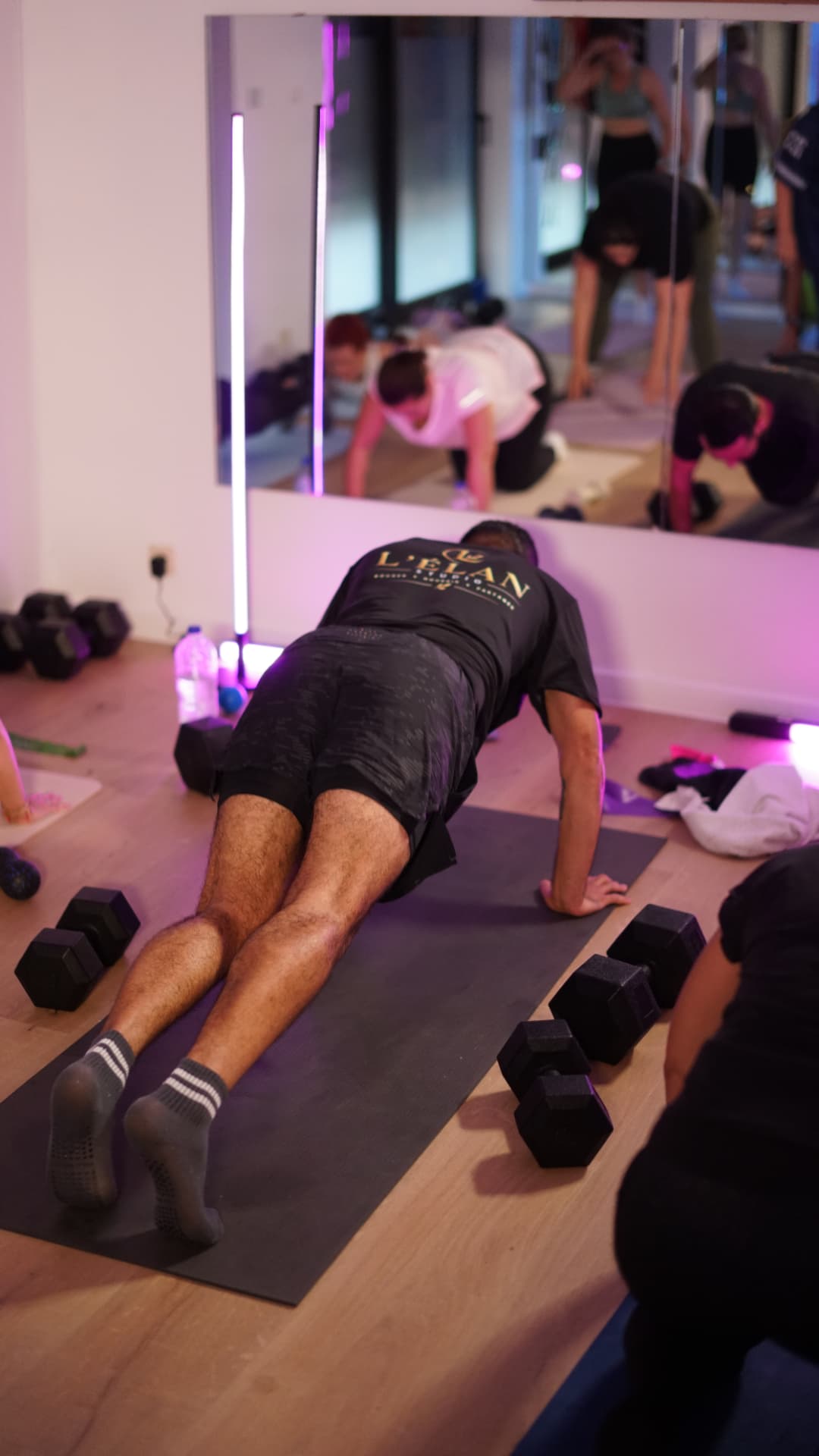 Participants en gainage avec haltères pendant un entraînement au studio L'ÉLAN à Maurage
