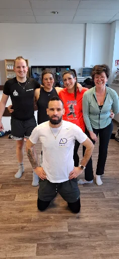 Petit groupe de membres posant avec Coach Saief après une séance